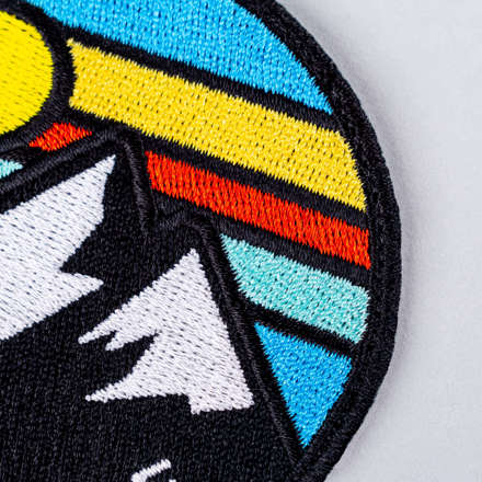 Embroidered mountain landscape patch close up