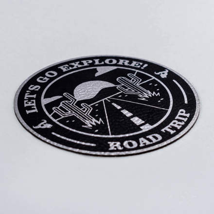 Black and Silver Faux Leather Go Explore patch laid at a hard angle